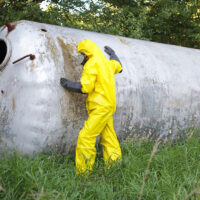 technician in uniform examining large stainless tank technician in uniform examining large stainless tank