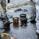 Workers remove crude oil from a beach Workers remove crude oil from a beach