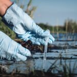 Water pollution concept. Woman scientist takes a water sample from polluted pond. Water pollution concept. Woman scientist takes a water sample from polluted pond.