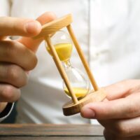 Businessman holds clock in hands. Concept of saving time and money. Time management. Planning work. Reduced cost and bureaucratic burden. Saving productivity. Extension of life. Debt / tax holidays Businessman holds clock in hands. Concept of saving time and money. Time management. Planning work. Reduced cost and bureaucratic burden. Saving productivity. Extension of life. Debt / tax holidays