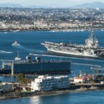 Aircraft Carrier and Sailboats in San Diego Bay in California Aircraft Carrier and Sailboats in San Diego Bay in California
