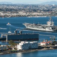 Aircraft Carrier and Sailboats in San Diego Bay in California
