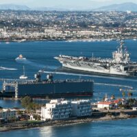 Aircraft Carrier and Sailboats in San Diego Bay in California Aircraft Carrier and Sailboats in San Diego Bay in California