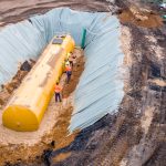 Worker installing a huge fuel tank